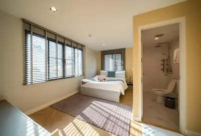 a bedroom with a bed and a bathroom at Triple Four in Bangkok