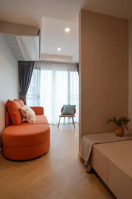 an orange ottoman in a room with a bedroom at Triple Four in Bangkok