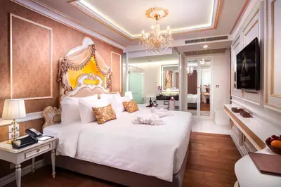 a bedroom with a large white bed and a chandelier at Amaranta Hotel in Bangkok