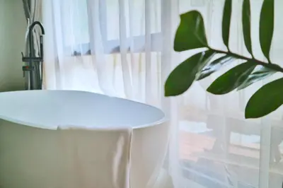 a plant sitting next to a window with a tub at YOLO Bangkok Boutique Hotel in Bangkok