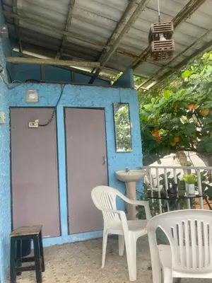 a patio with two white chairs and a door at New Phiman Riverview Guesthouse in Bangkok