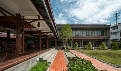 a building with a patio and a garden at Kasayapi Hotel in Bangkok