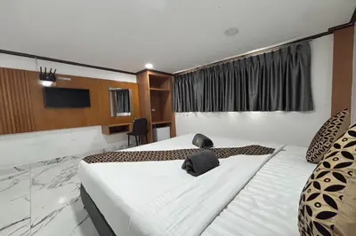 a hotel room with two beds and a television at Papa Ji Hotel and Restaurant in Bangkok