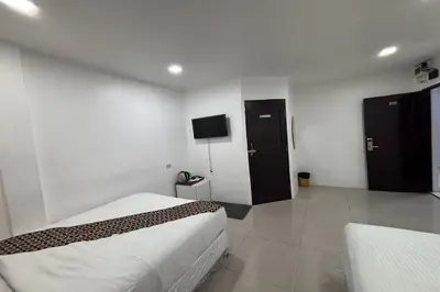 a hotel room with two beds and a tv at Papa Ji Hotel and Restaurant in Bangkok
