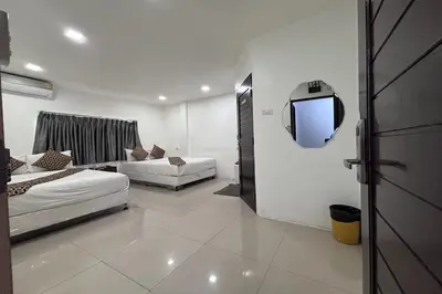 a room with two beds and a tv in it at Papa Ji Hotel and Restaurant in Bangkok