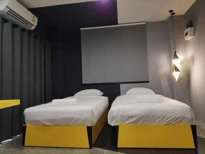 two beds in a room with a projection screen at Ratch66 Huai Khwang MRT in Bangkok