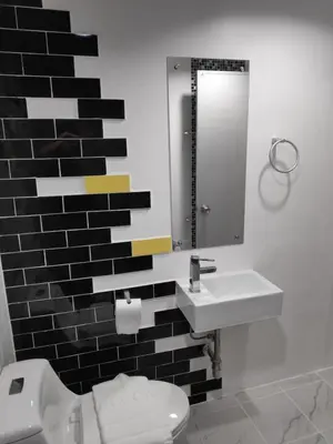 a bathroom with a toilet and a sink and a mirror at Ratch66 Huai Khwang MRT in Bangkok