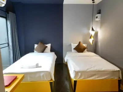 two beds in a room with blue walls at Ratch66 Huai Khwang MRT in Bangkok