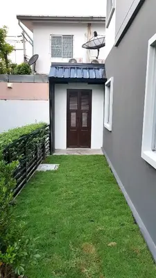 a view of the front door of a house with grass at NIDO Guest House in Ban Bang Phang