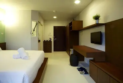 a hotel room with a bed and a television at Loft 77 in Bangkok