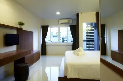 a hotel room with a bed and a window at Loft 77 in Bangkok