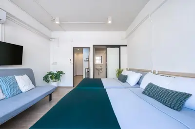 a living room with a large couch and a blue sofa at Platinum Deluxe Shopping Apartments in Bangkok