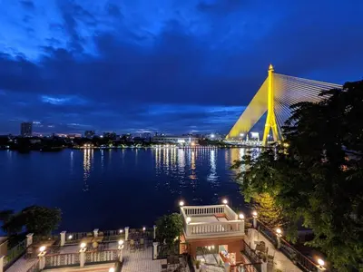 a view of a bridge over a river at night at Hiranyakul House Riverside in Bangkok