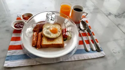 a plate of breakfast food with an egg and toast at Azure Hostel Bangkok in Bangkok