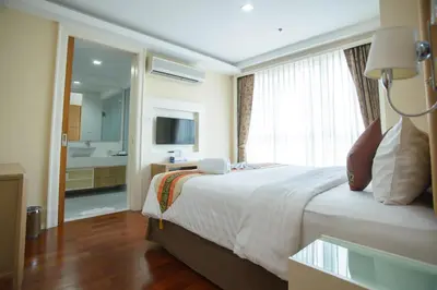 a hotel room with a bed and a large window at GM Serviced Apartment in Bangkok