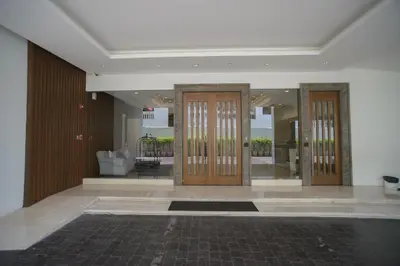 a hallway with three wooden doors in a building at GM Serviced Apartment in Bangkok