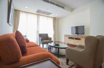 a living room with a couch and a tv at GM Serviced Apartment in Bangkok