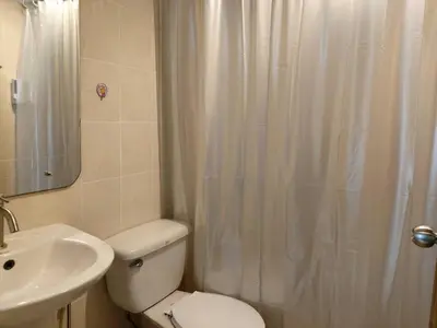 a bathroom with a toilet and a sink and a shower at Hotel Paraiso in Bangkok