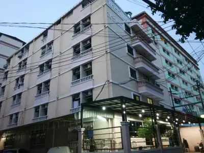 a large white building with windows and balconies at Hotel Paraiso in Bangkok