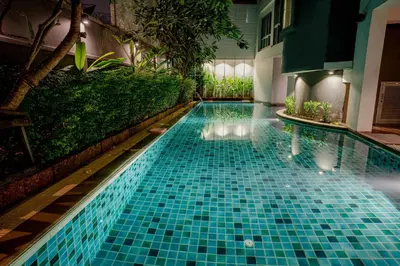 a swimming pool with blue tiles in a building at Peace Land Khaosan in Bangkok