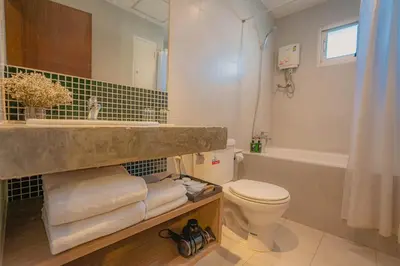 a bathroom with a sink and a toilet and a tub at Peace Land Khaosan in Bangkok