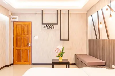 a room with a bed and a wooden door at Tree Place in Bangkok