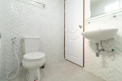 a bathroom with a white toilet and a sink at Tree Place in Bangkok