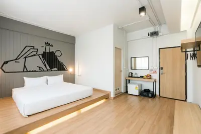 a bedroom with a white bed and a desk at Marwin Villa in Bangkok