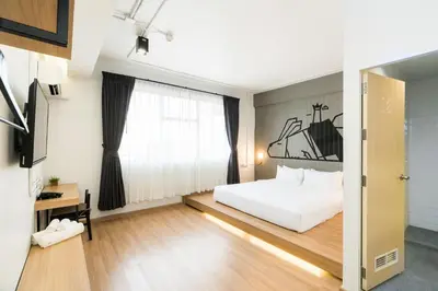 a bedroom with a white bed and a window at Marwin Villa in Bangkok