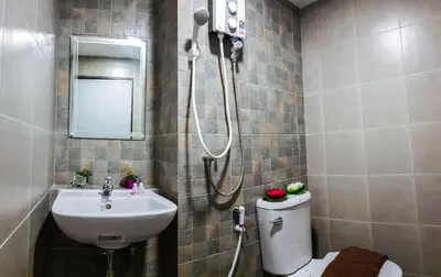 a bathroom with a sink and a toilet and a shower at Kim Korner Hotel in Bangkok