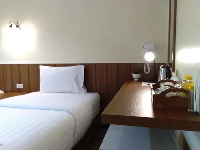 a hotel room with a bed and a wooden desk at Baan Wanchart in Bangkok