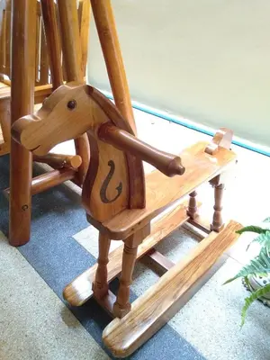 a wooden rocking chair with a horse on it at Baan Wanchart in Bangkok