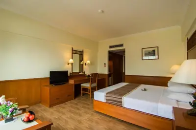 a hotel room with a bed and a desk at Bangkok Palace Hotel in Bangkok