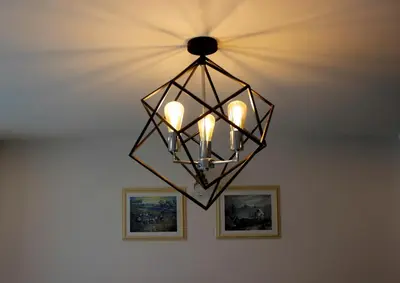 a chandelier hanging from a ceiling with two pictures at V One Pride-Sukhumvit 22, Bangkok in Bangkok