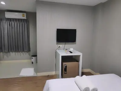 a room with a bed and a tv on a wall at Tim Place - BTS Phra Khanong in Bangkok