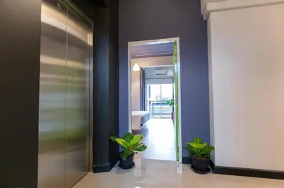 a hallway with a glass door and potted plants at Mango 10 House in Bangkok