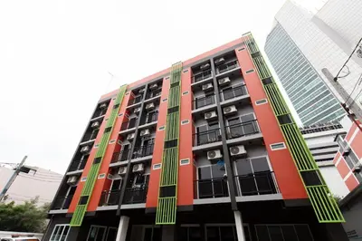 a red building with green shuttered windows at Mango 10 House in Bangkok