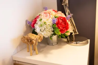 a vase of flowers on a table next to a flower arrangement at Mango 10 House in Bangkok