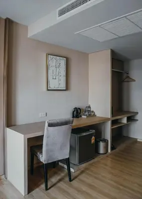 a room with a desk and a chair in a room at De Prime Rangnam Hotel in Bangkok