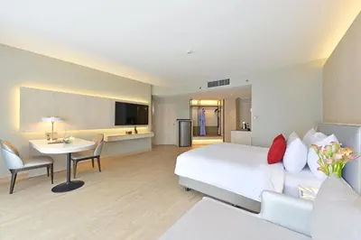 a large hotel room with a bed and a table at Centre Point Plus Hotel Pratunam in Bangkok