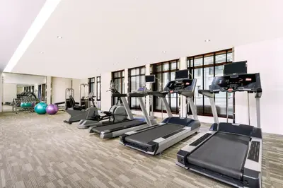 a gym with several treadmills and elliptical machines at Centre Point Hotel Chidlom Bangkok in Bangkok