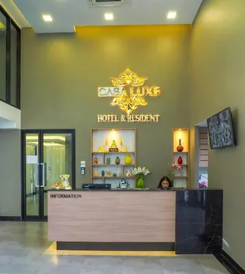 a woman sitting at a counter in a hotel lobby at Casa Luxe Hotel and Resident in Bangkok