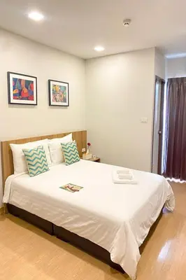 a bedroom with a large white bed with two pillows at Casa Luxe Hotel and Resident in Bangkok