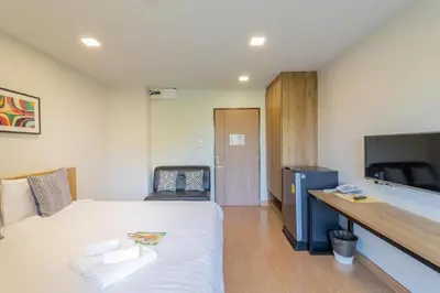 a bedroom with a large white bed and a desk at Casa Luxe Hotel and Resident in Bangkok