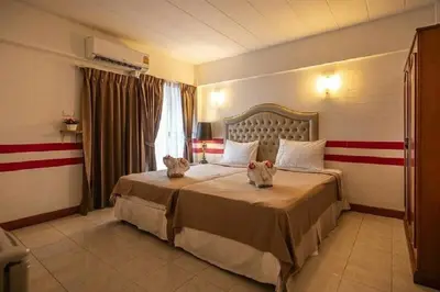 a hotel room with a large bed with flowers on it at SUDYOD HOTEL in Ban Bang Bamru