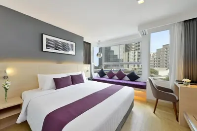 a hotel room with a large bed and a window at Arize Hotel Sukhumvit in Bangkok