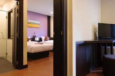 a hotel room with a bed and a tv in it at Tara Place Hotel Bangkok in Bangkok