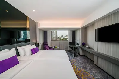 a hotel room with a large bed and a flat screen tv at Hotel JAL City Bangkok in Bangkok