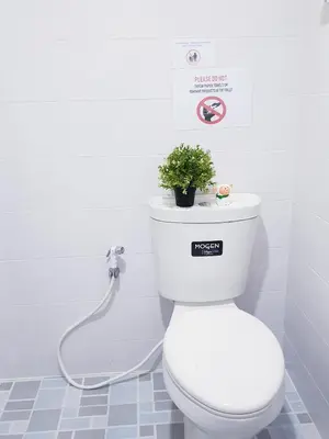 a white toilet with a plant on top of it at NK Guesthouse 2 in Bangkok
