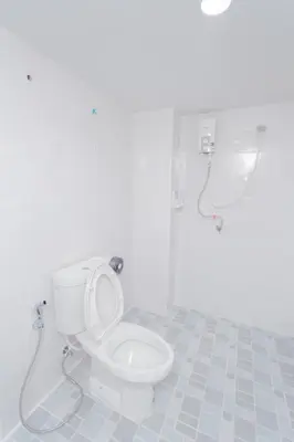 a white bathroom with a toilet and a shower at NK Guesthouse 2 in Bangkok
